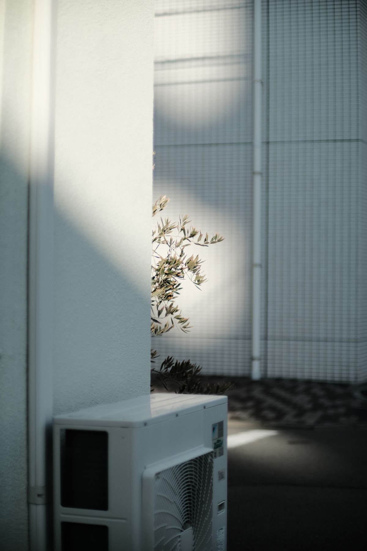 Air conditioning unit installed on a white building corner