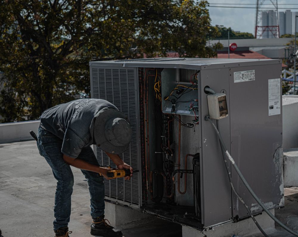 Technician carrying out maintenance on a rooftop AC unit