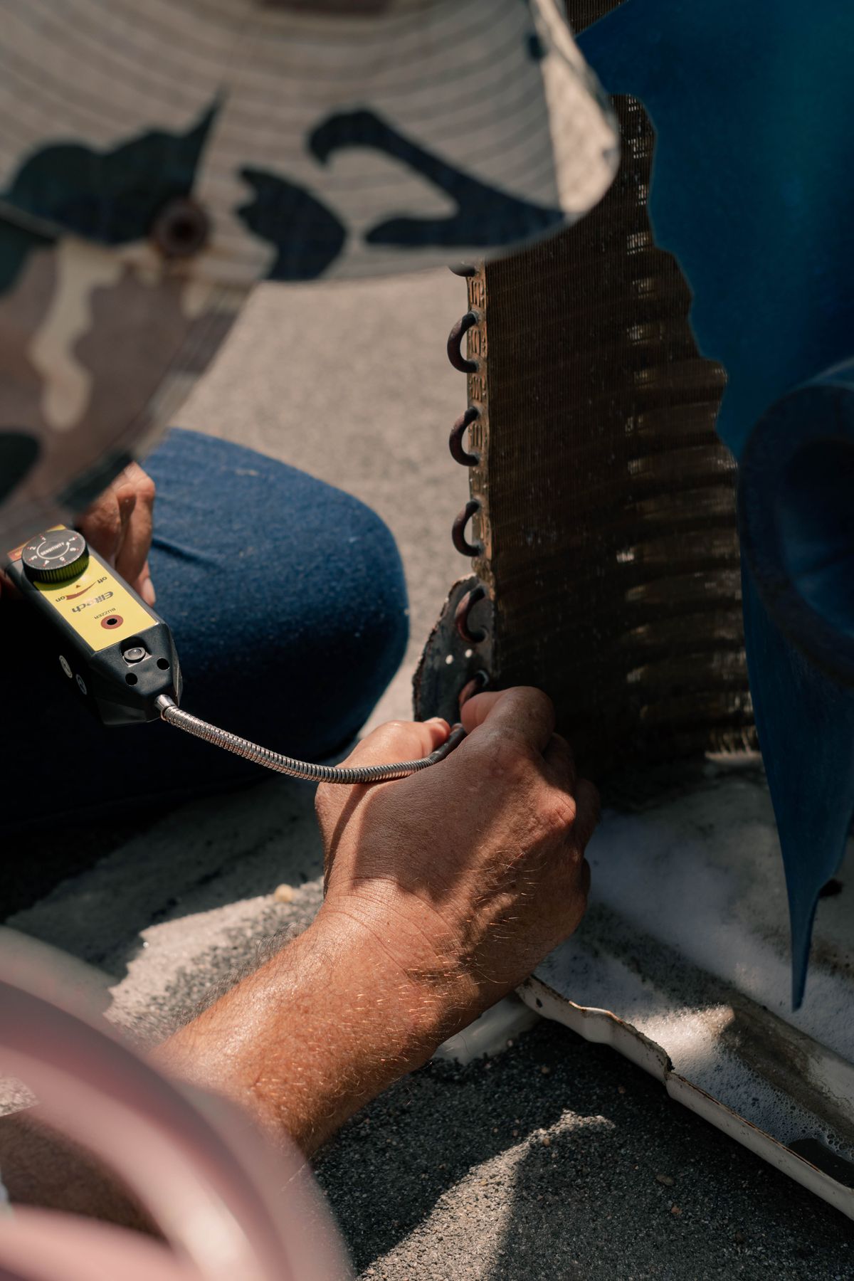 Technician working on AC unit components with hand tools