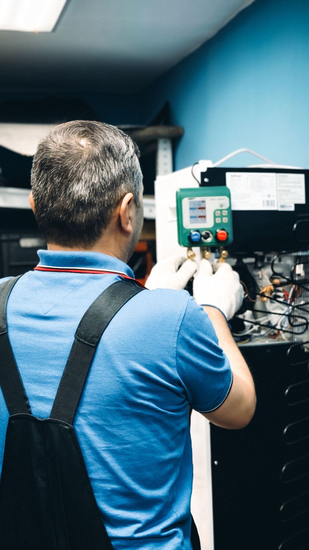 Technician carrying out air conditioning maintenance indoors