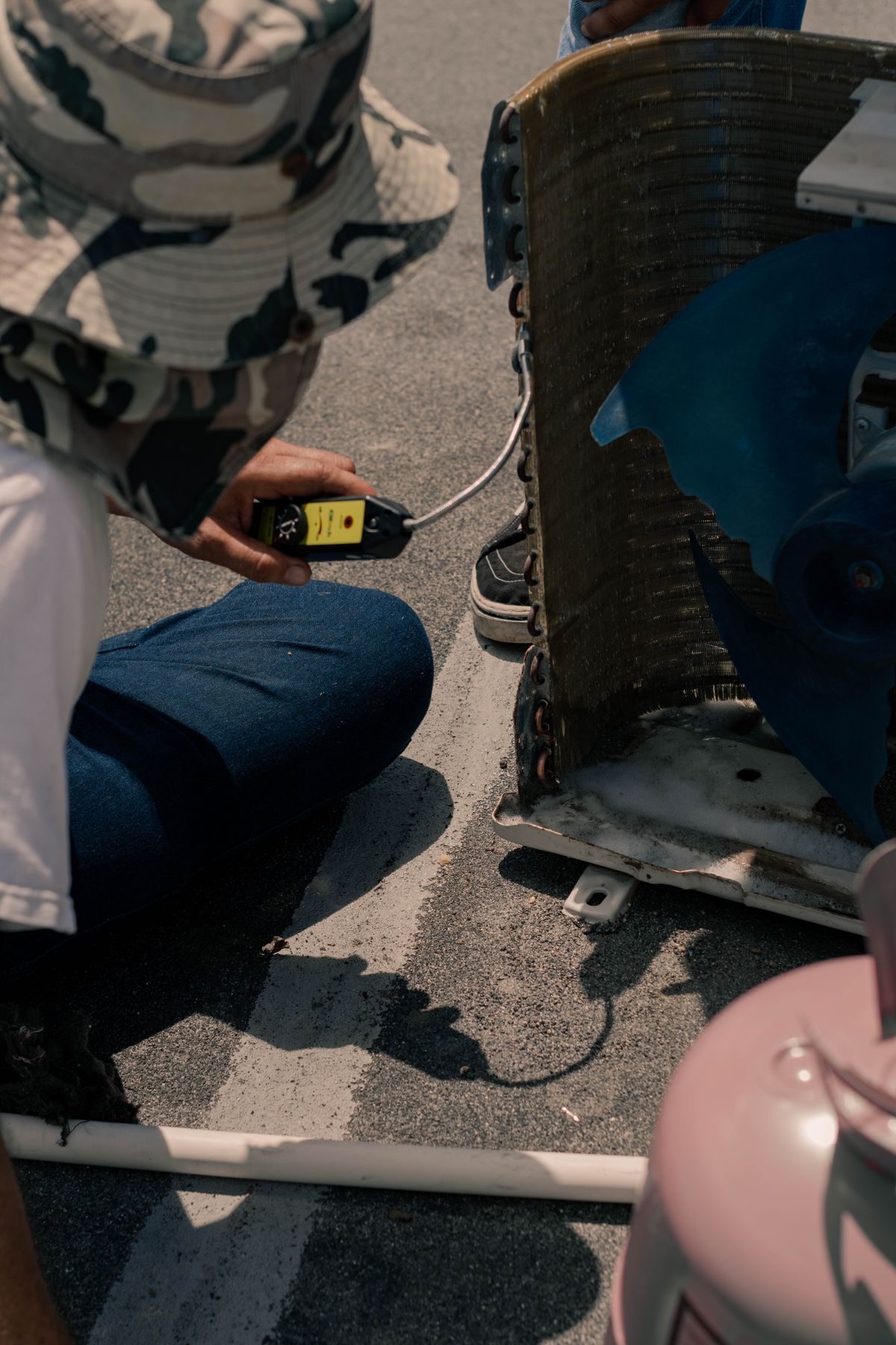 Technician testing an AC unit with a multimeter